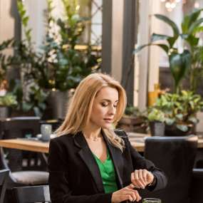 beautiful-woman-sitting-at-table-and-checking-time-2023-11-27-05-16-42-utc-1.jpg