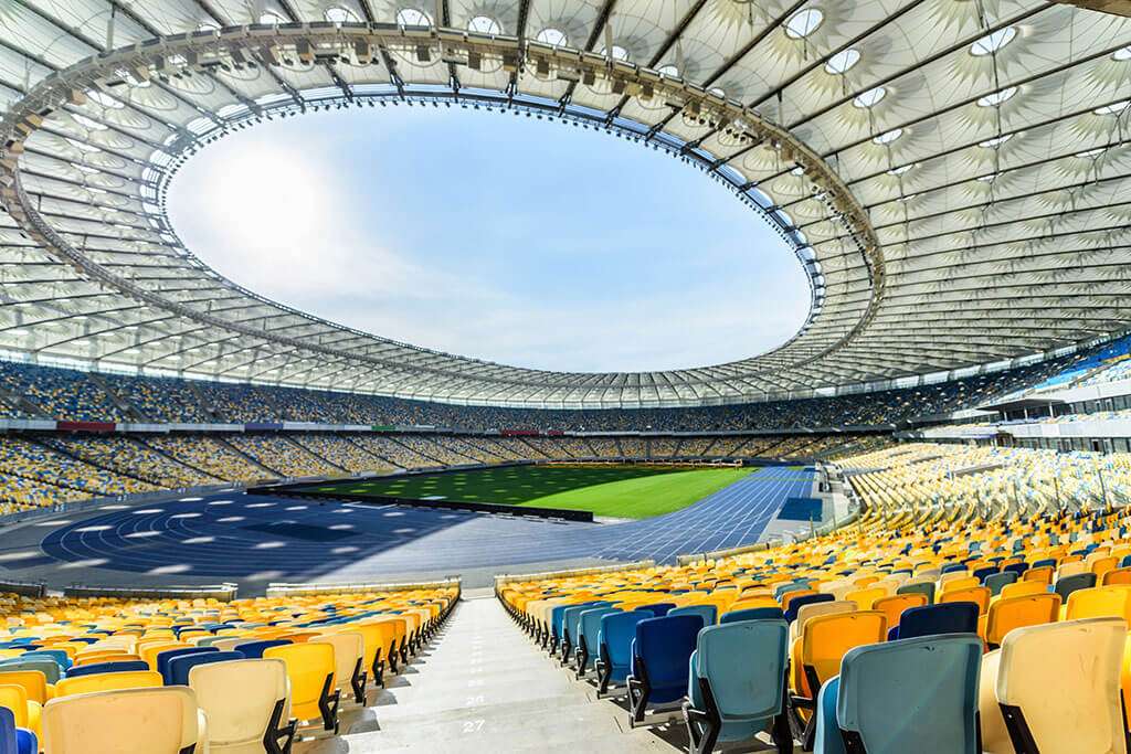 rows-of-yellow-and-blue-stadium-seats-on-soccer-fi-T7AKFMB.jpg