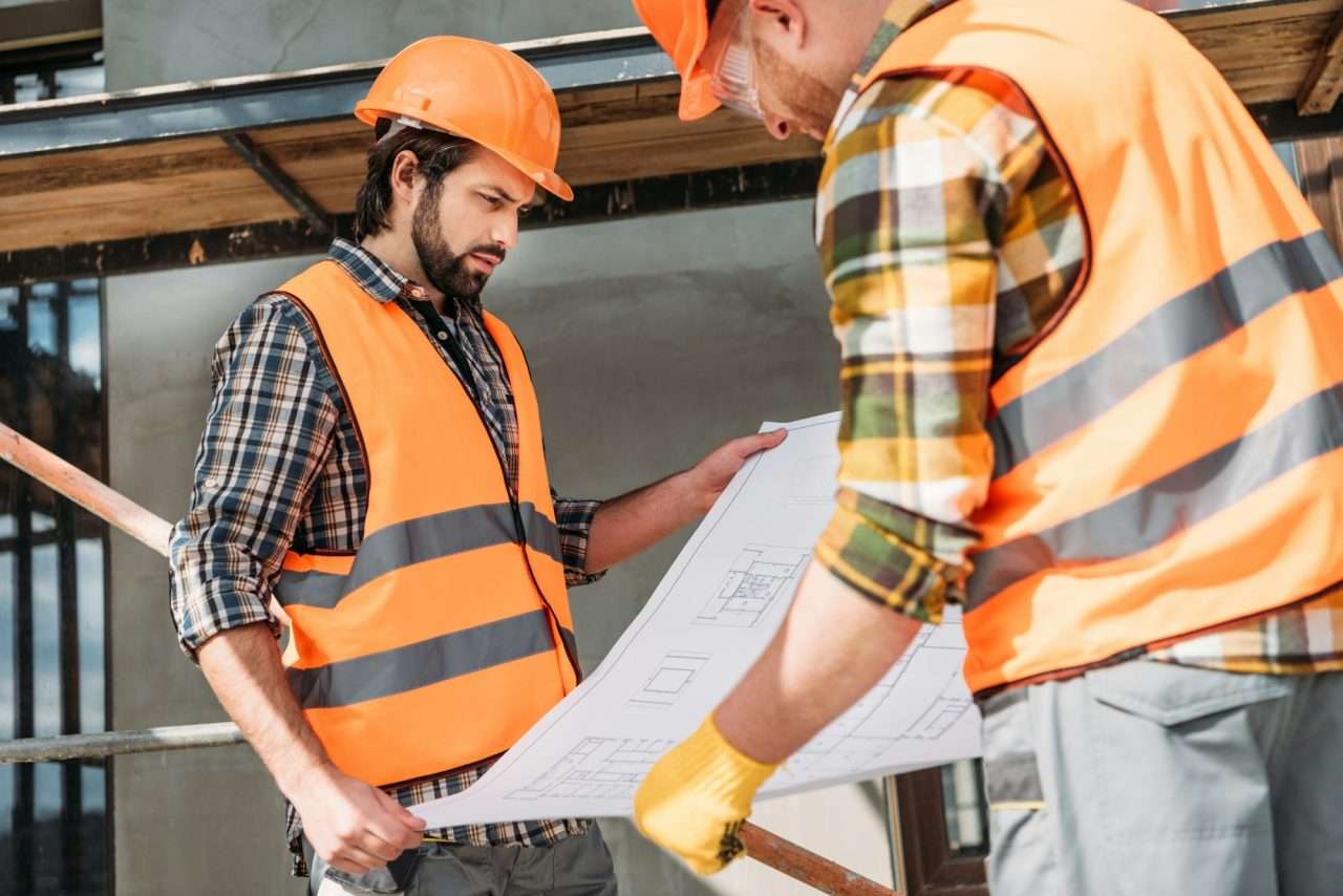 thoughtful-builders-with-blueprint-at-construction-site.jpg